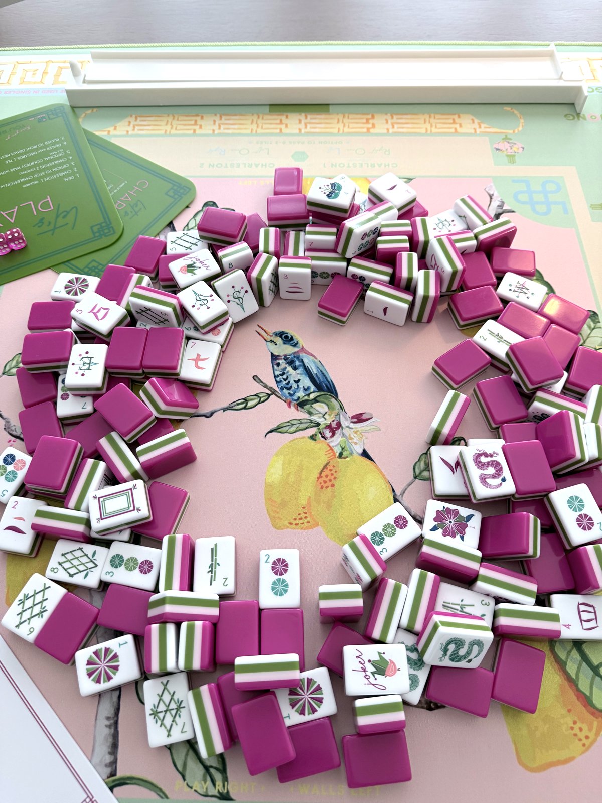 Overhead of magenta-and-green Dandy tiles ringing the watercolor songbird and lemon centerpiece of the Citrus Songbird mat